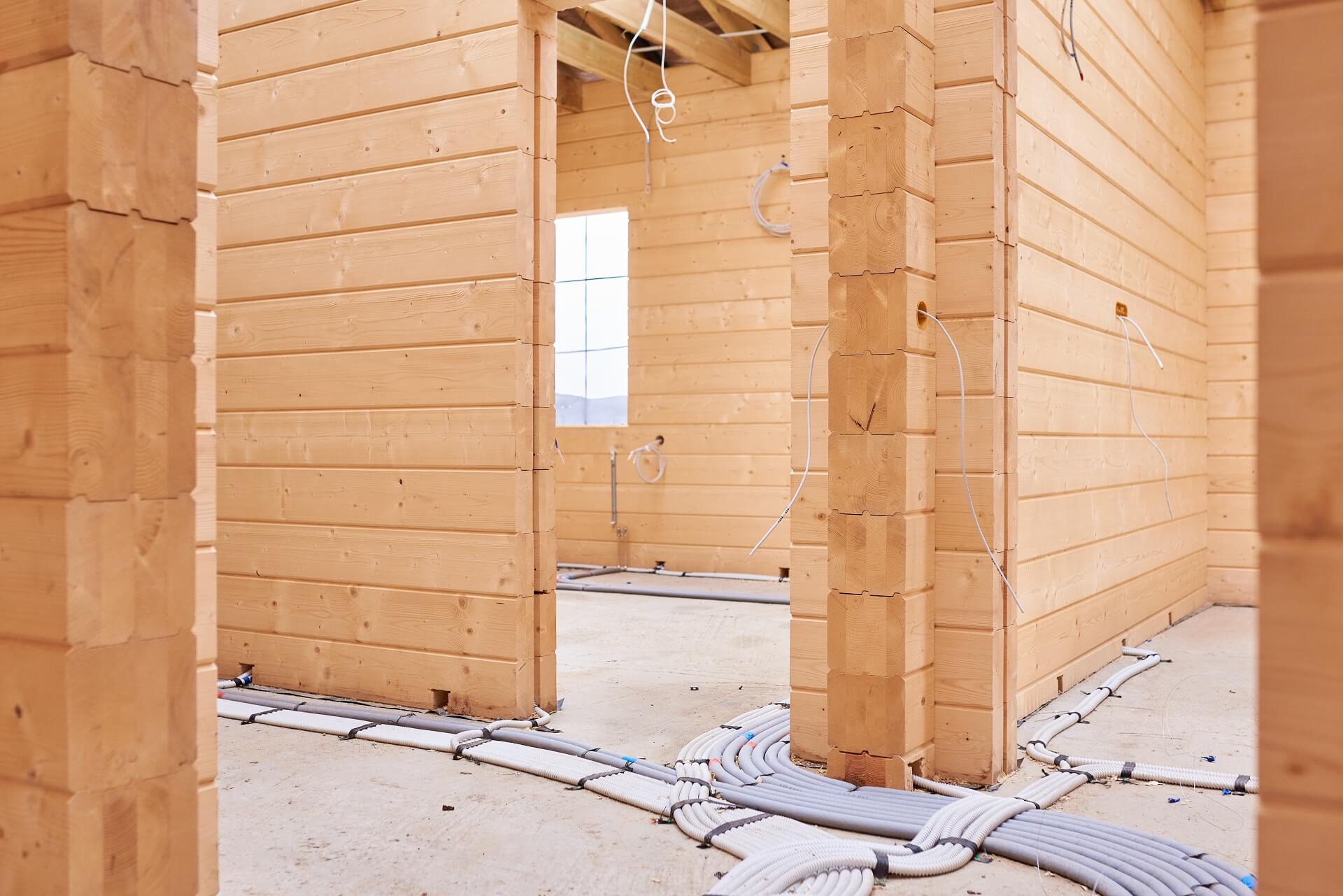 Ein Bild, das die Innenansicht eines im Bau befindlichen Holzhauses zeigt. Erfahren Sie mehr über die handwerkliche Präzision und den Fortschritt dieses beeindruckenden Bauprojekts.
